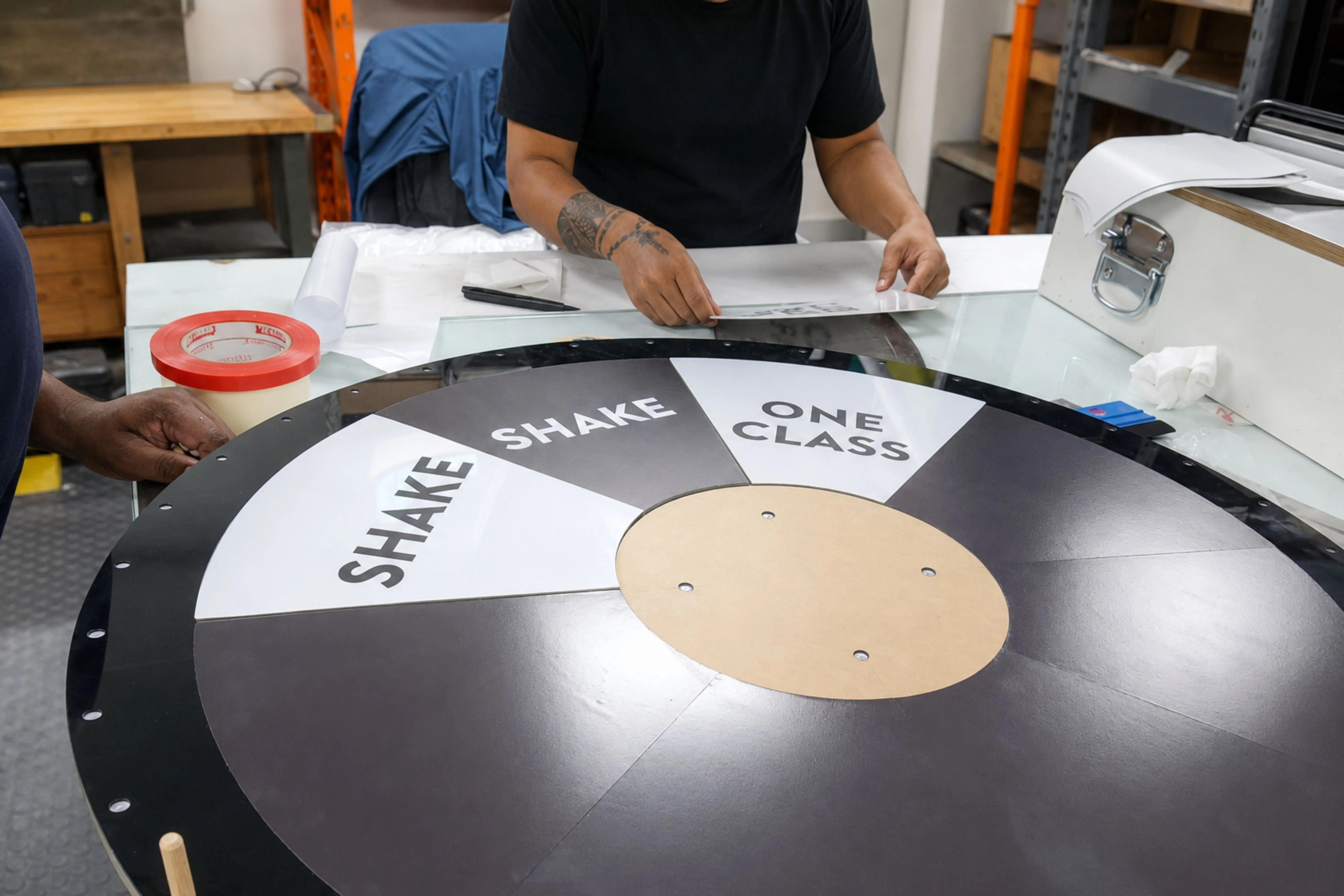 The 1Rebel prize wheel mid-assembly on the NSQD workshop bench, prize sectors visible