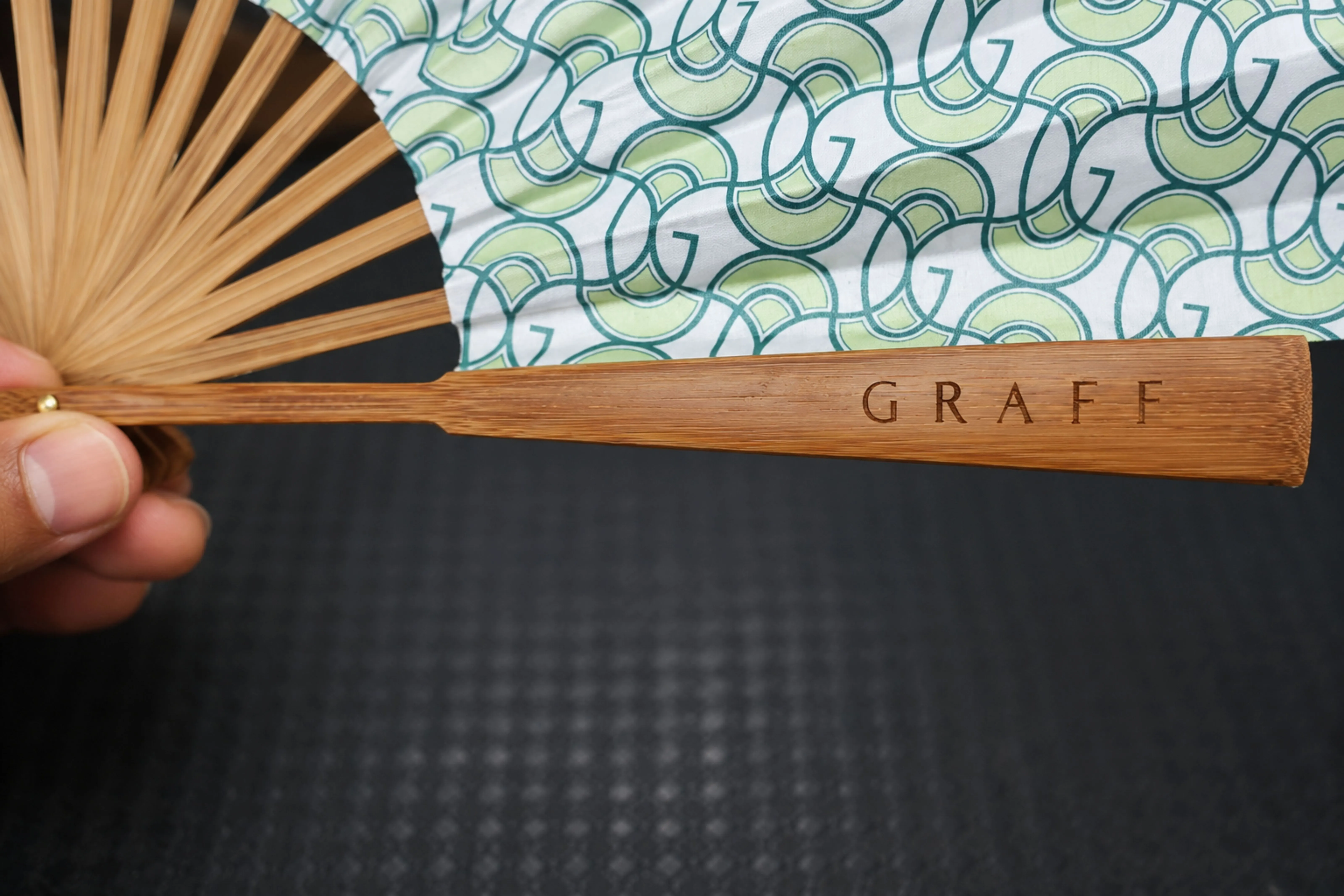 Close-up of the GRAFF wood-burn engraving on the bamboo fan handle